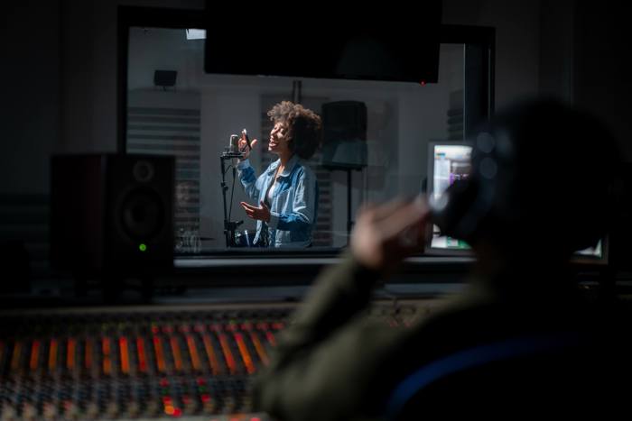 Singer and producer recording a song in the studio